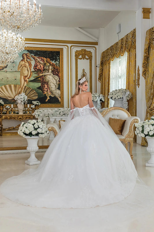 Bride in a white wedding dress standing in an opulent room with decorative elements.