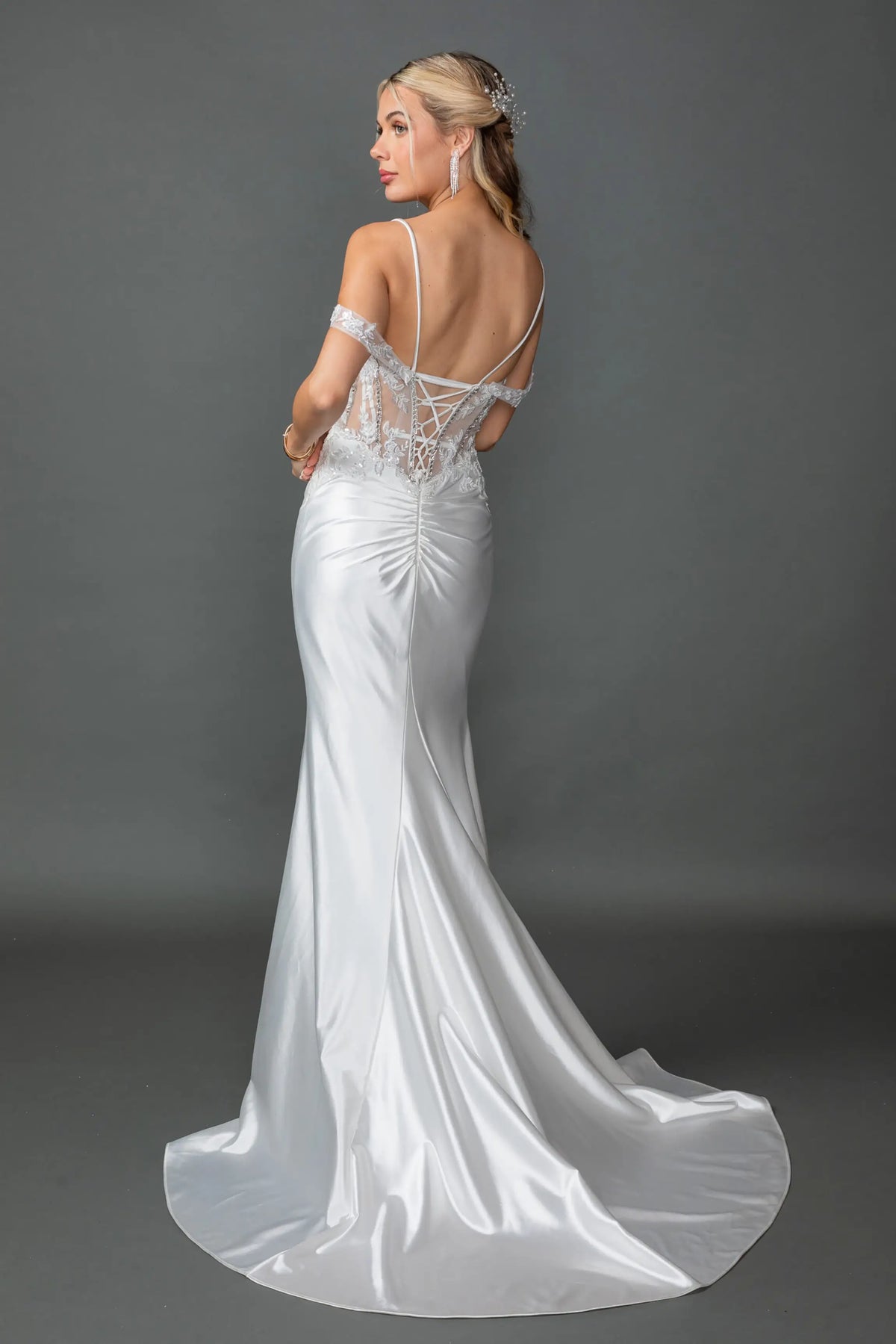 Revealing an open back above its satin train, this Off-White wedding dress is shown from the back.
