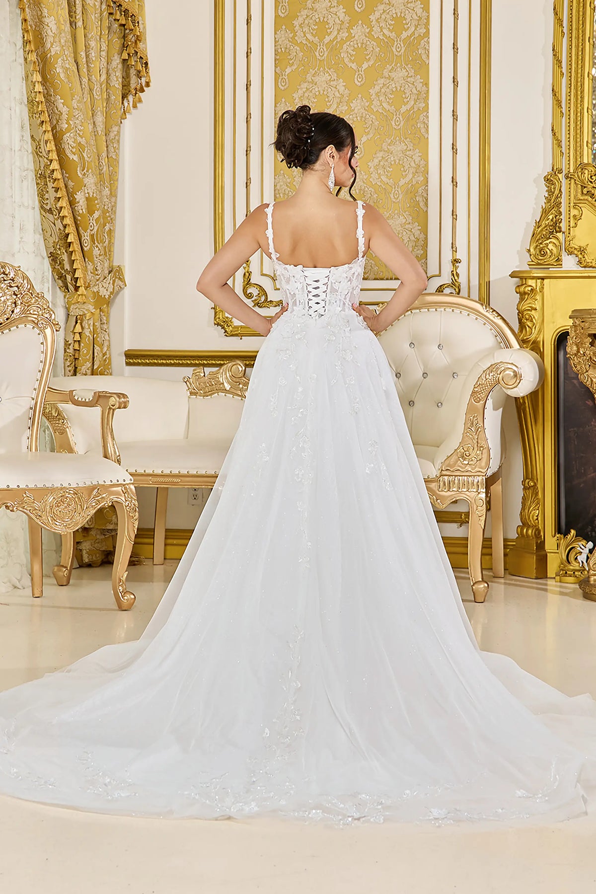 Revealing corset lacing and a soft tulle train, this Off-White wedding dress is shown from the back.