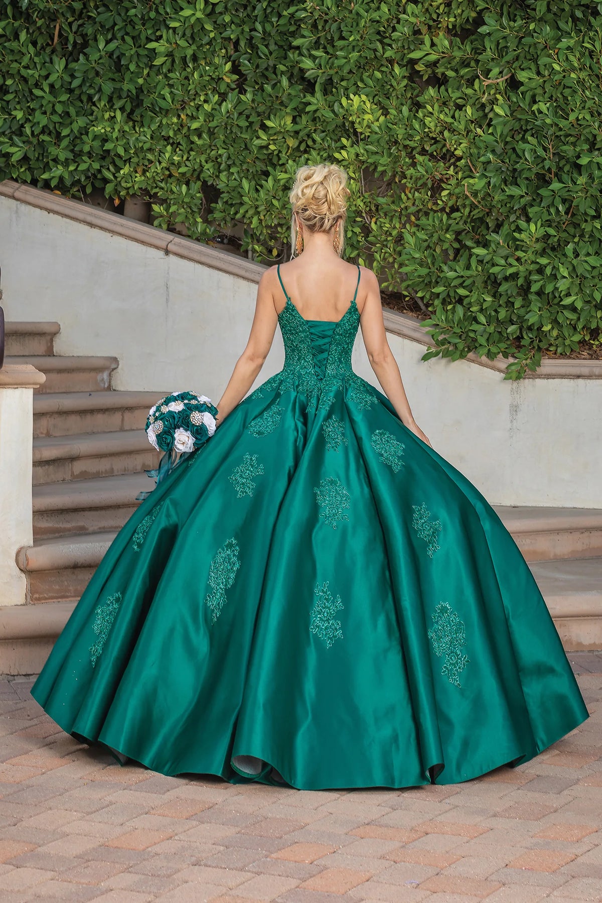 From the back, the Hunter Green quinceañera ball gown reveals its floor-length skirt.