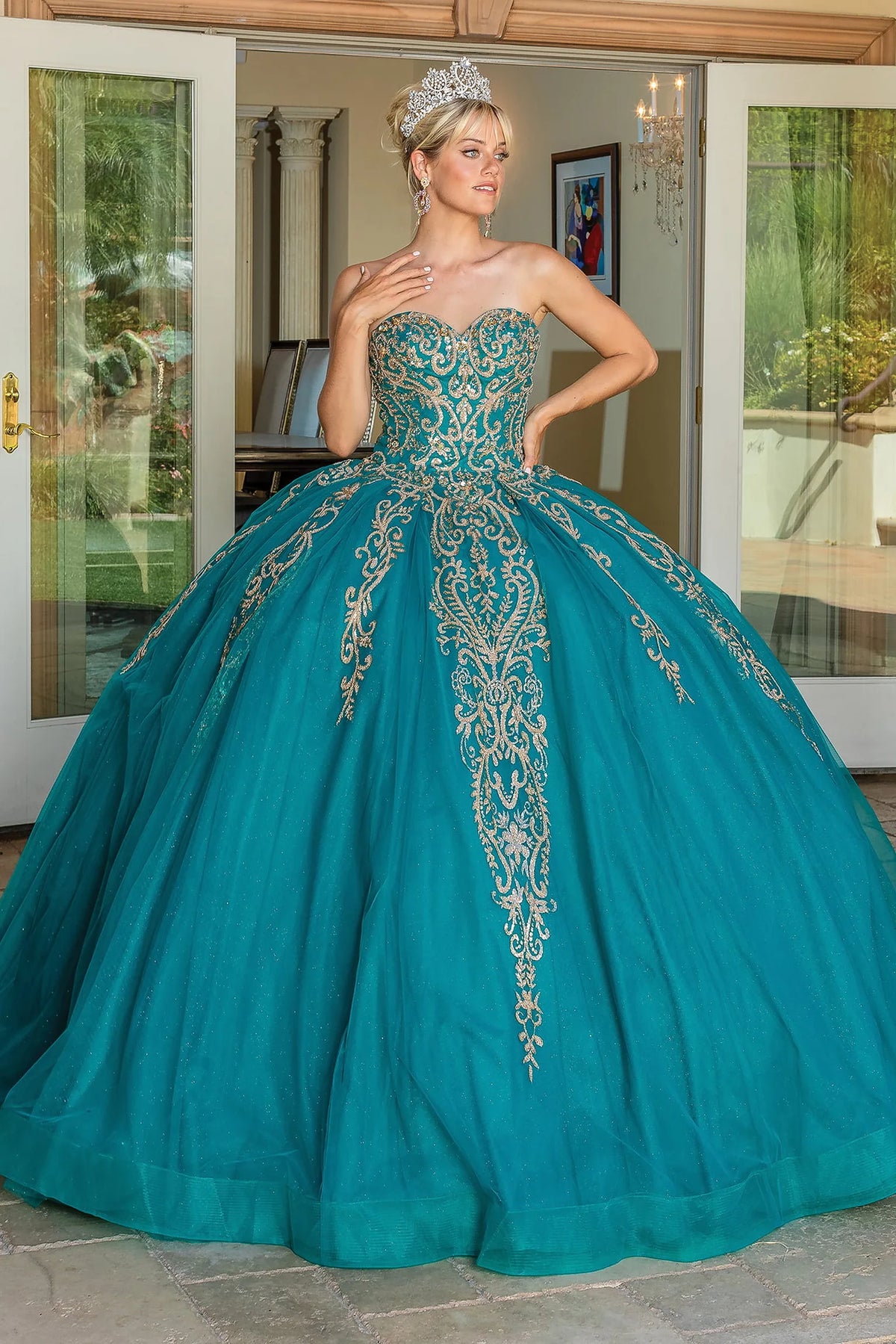Showing ornate beadwork across its strapless bodice, this Teal quinceañera ball gown is shown in full view.