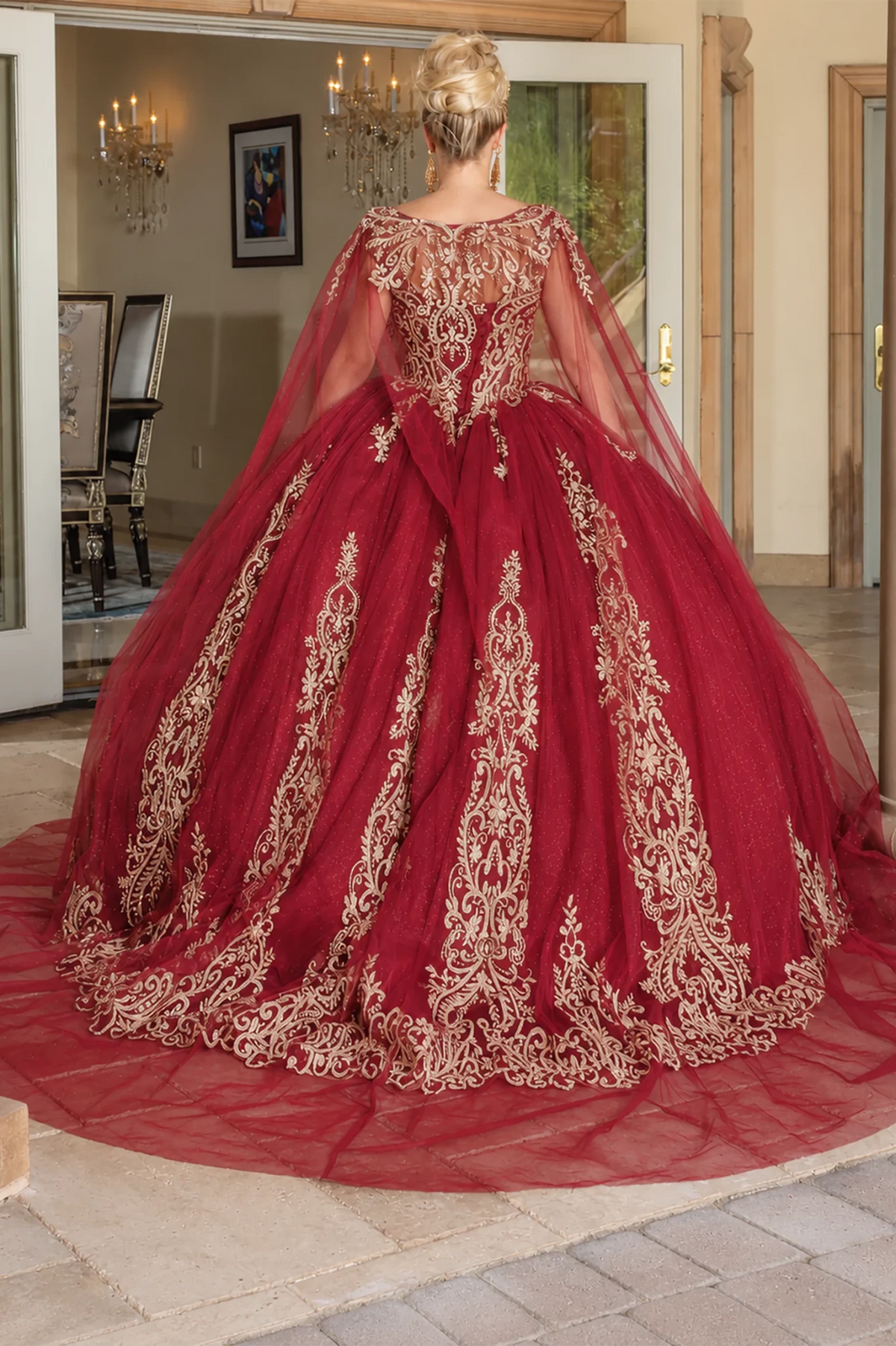 burgundy ball gown with extensive gold lace embroidery, lace up back and a sheer draped cape