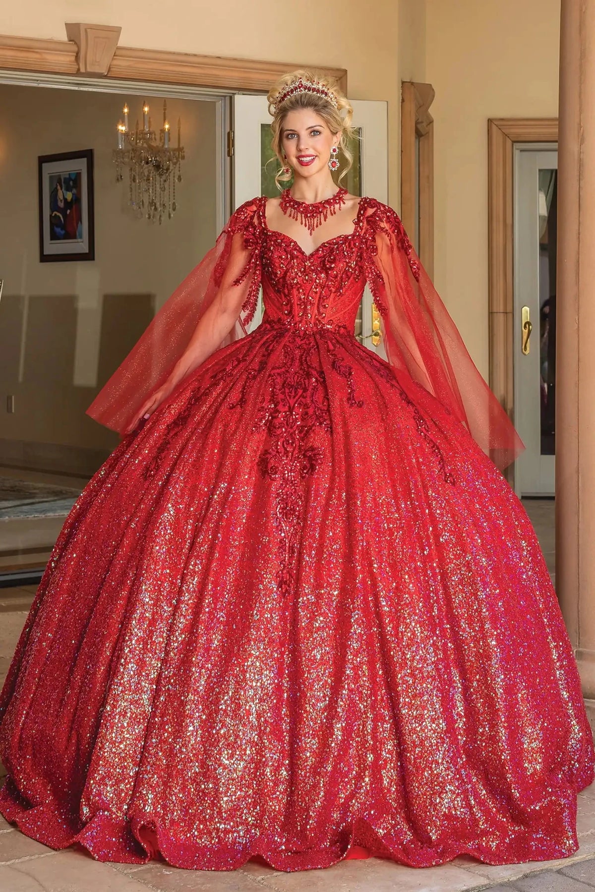 Additional full-length view of a Red quinceañera gown highlighting sequined lace, dramatic sheer cape, and scoop neckline