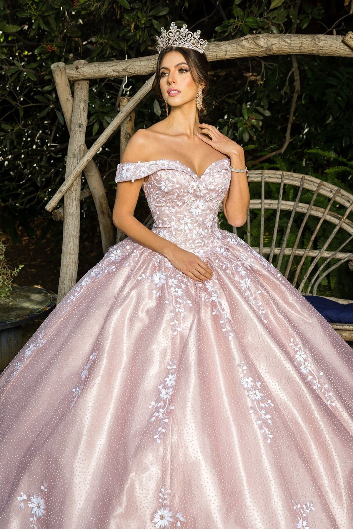 Close-up view reveals a dusty rose quinceanera dress with sequin floral embroidery, embossed tulle, and satin train.