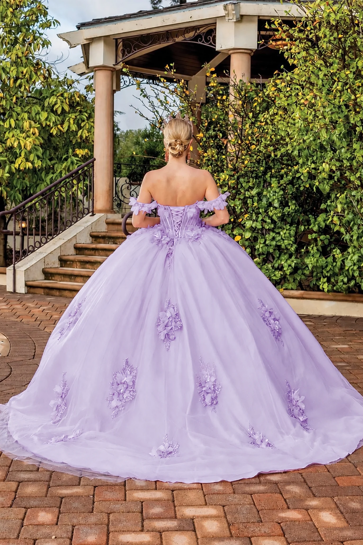 Back view of a Lilac quinceañera gown showing lace-up back and floral appliqués