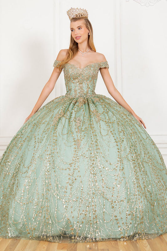 Woman standing front-facing in light sage ball gown with gold embellishments, off-the-shoulder bodice, voluminous skirt, and ornate crown in elegant indoor setting