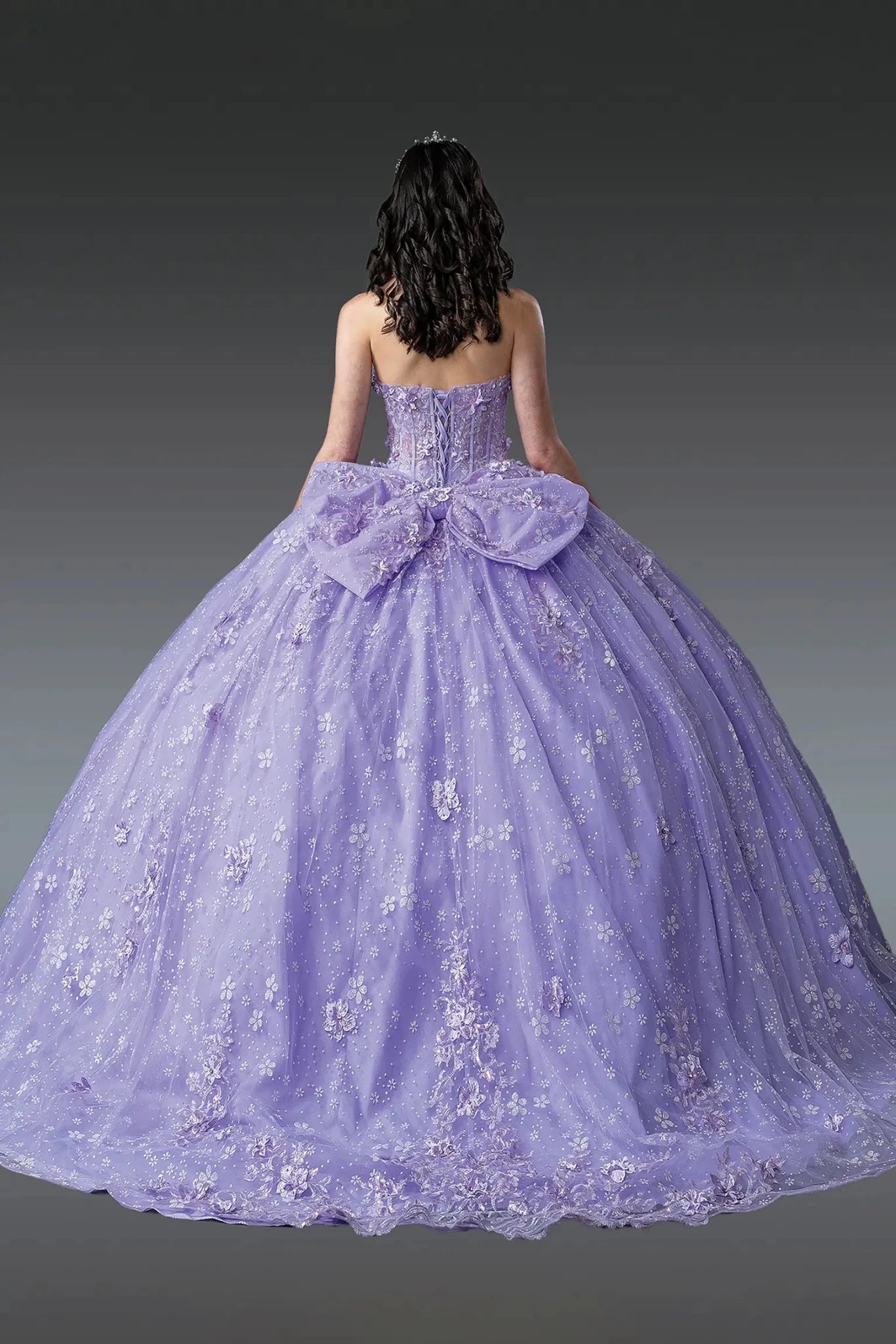 lilac ball gown with a large bow and 3d floral appliques on a plain background