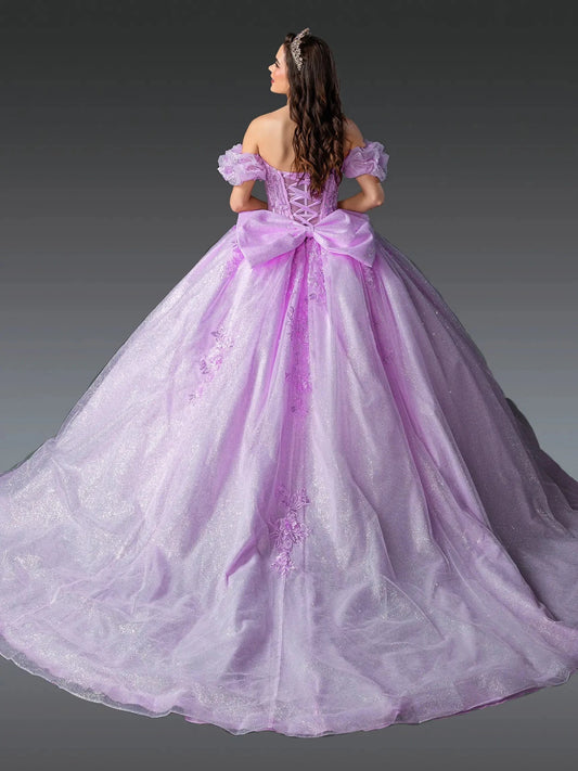 Woman standing back-facing in lilac quinceañera ball gown with off-shoulder sleeves, lace-up embroidered bodice, floral appliqués, and flowing sparkling skirt with train