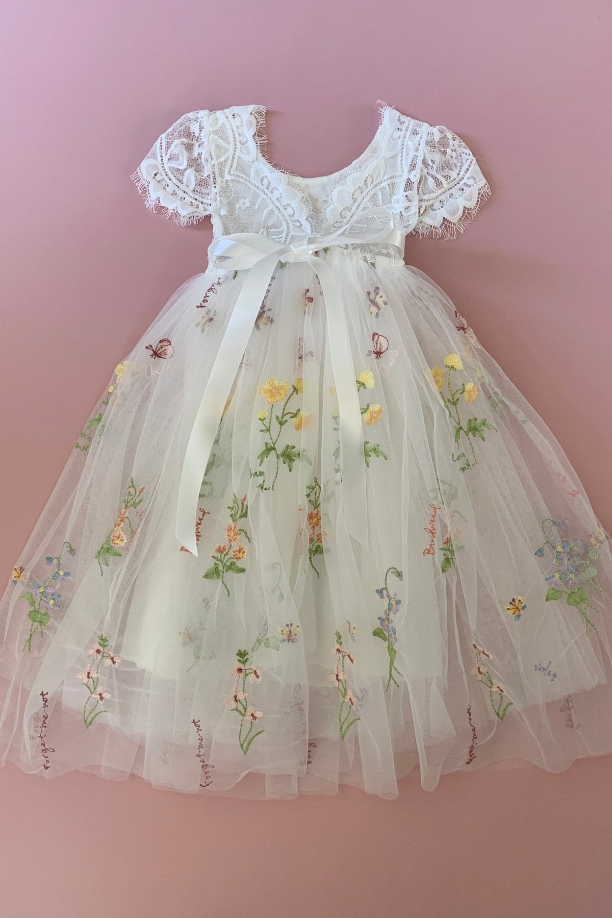 Detailed view highlights Boho lace flower girl dress with floral embroidery.