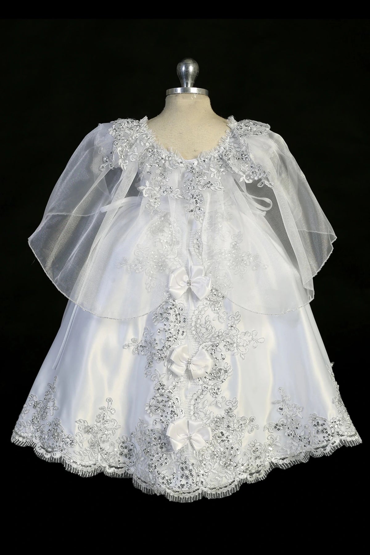 Detail of the white baptism dress showing rhinestone waist accent and split organza skirt.