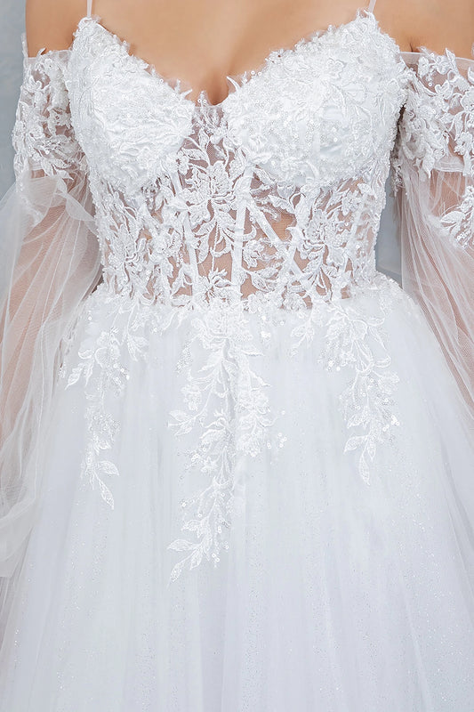 Close-up of a white lace wedding dress with sheer sleeves.