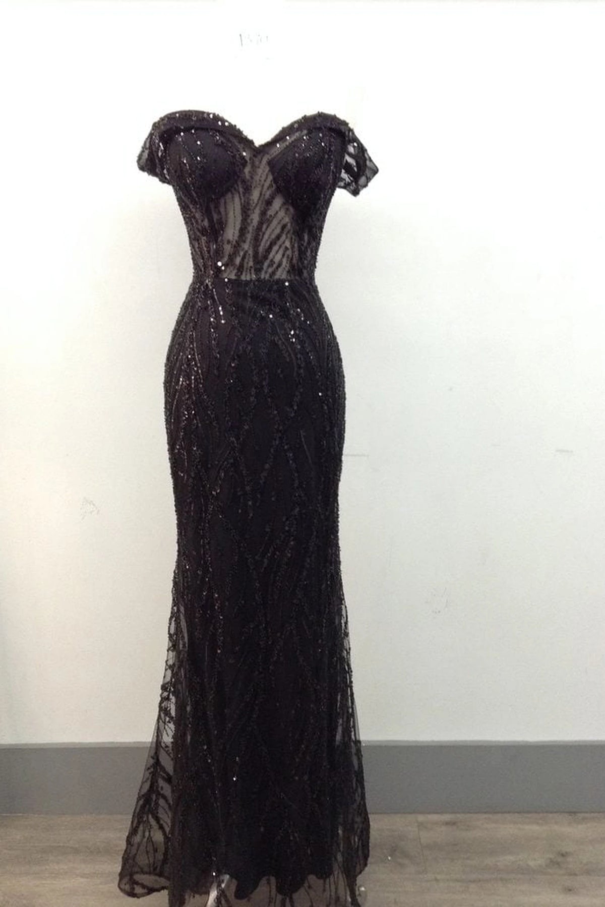 Featuring a floor-length skirt, this Black prom dress is shown in full view.