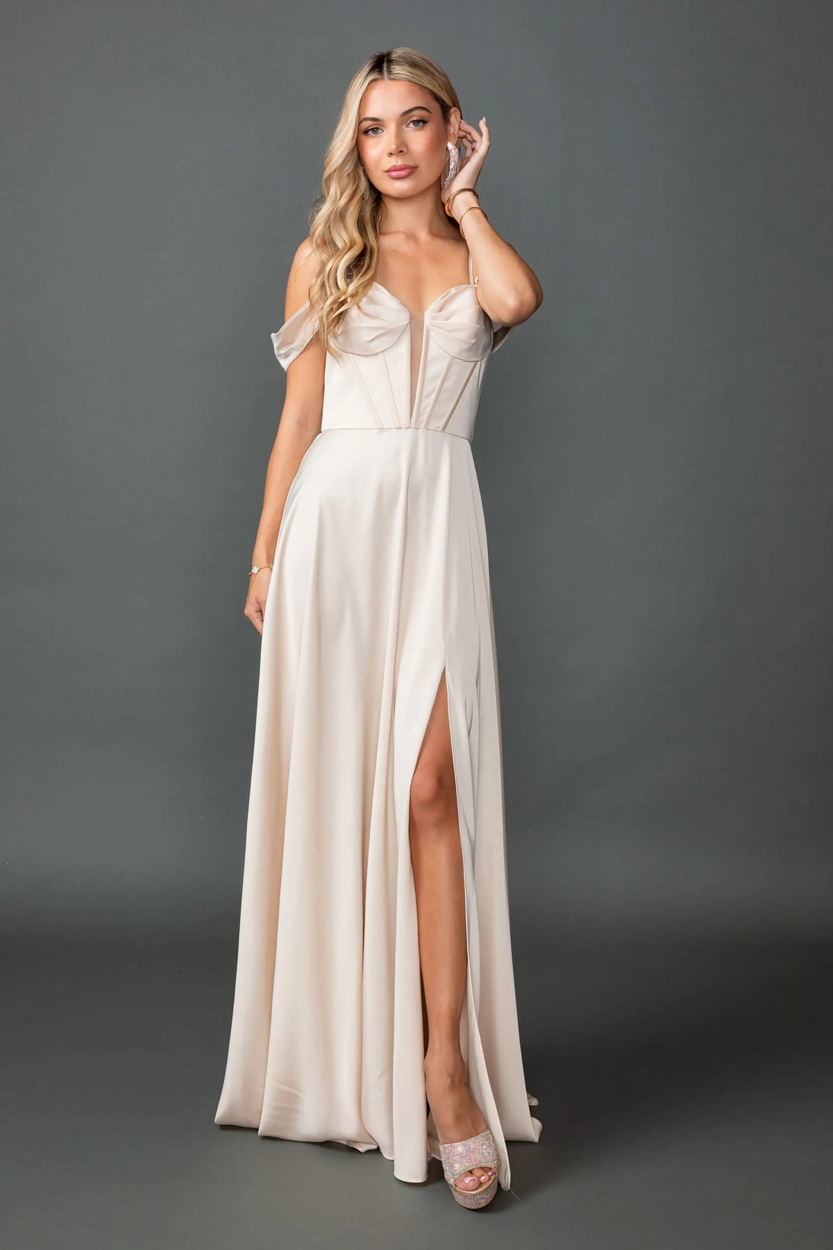 Showing a sweetheart bodice and high-slit satin skirt, this Champagne prom dress is shown in full view.