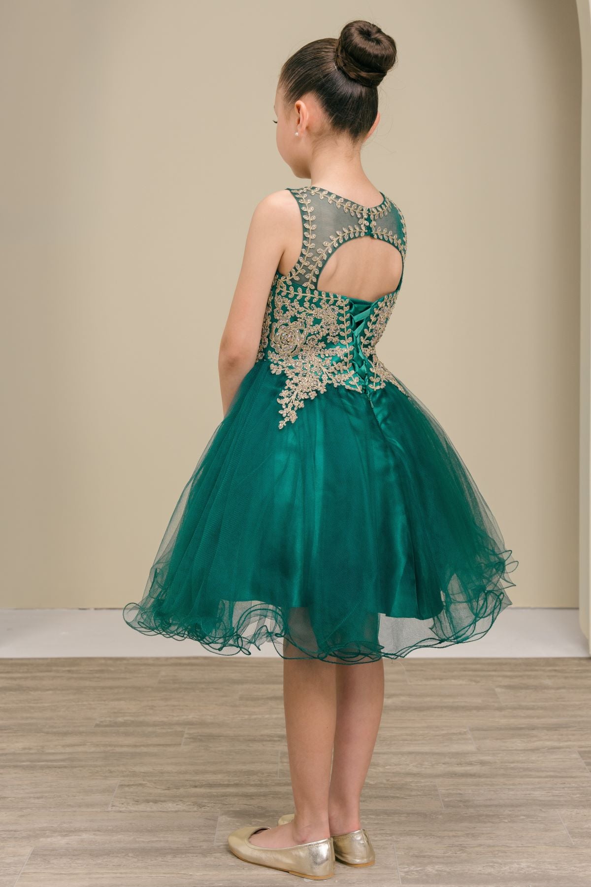 Hunter green flower girl dress back view highlighting flowing tulle skirt and elegant silhouette.