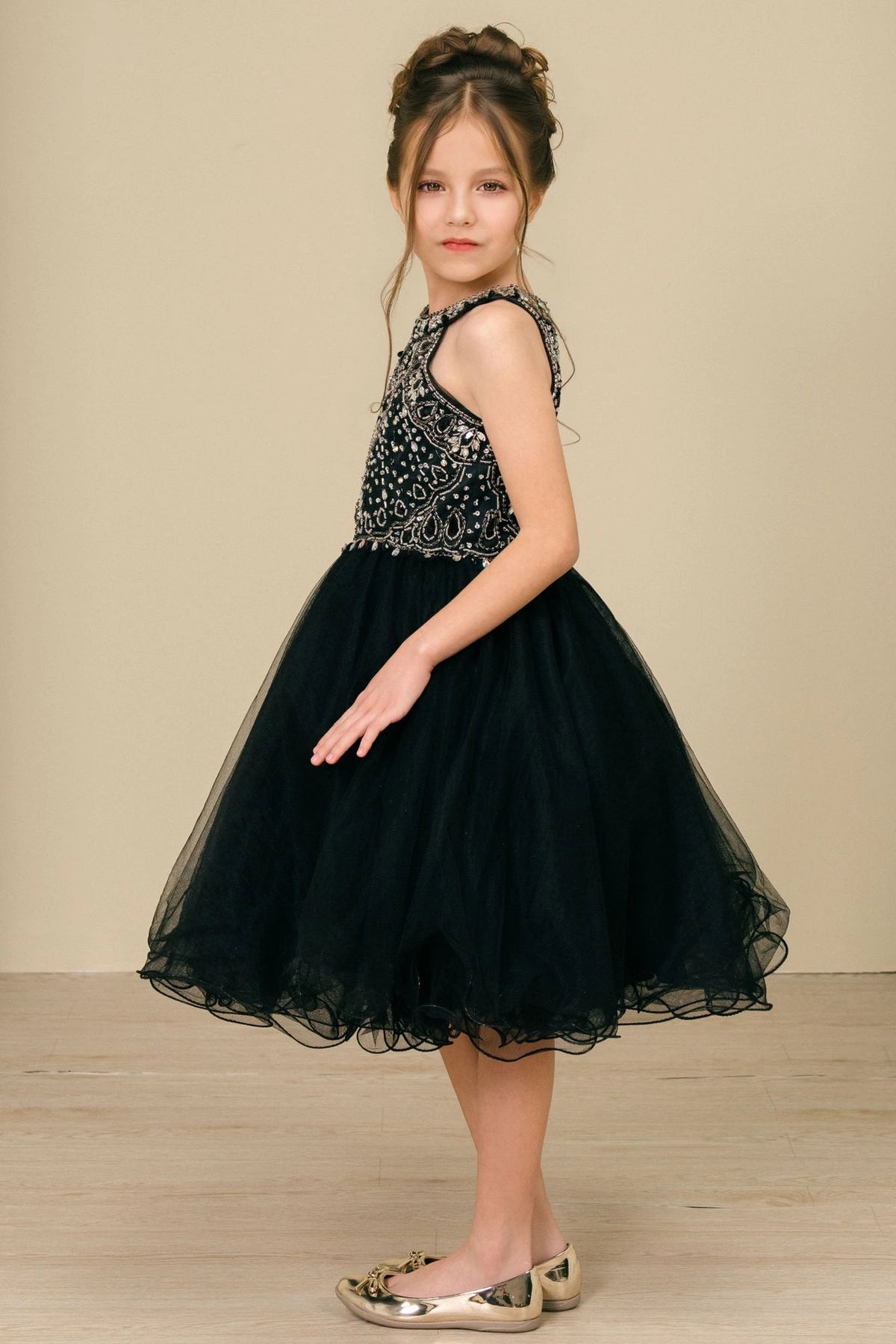 Detailed by a beaded keyhole back, the Black kids party dress reveals its construction.