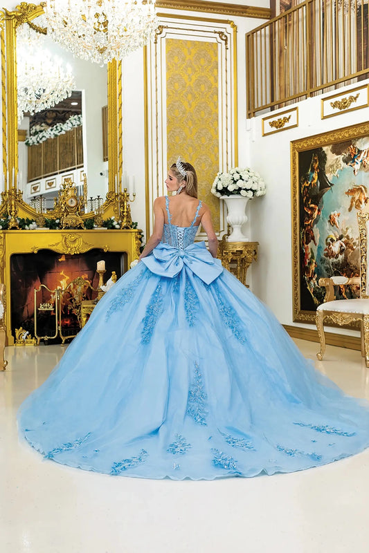 Back view of light blue quinceañera ball gown featuring a lace-up corset back, oversized bow detail, and long flowing tulle train with applique accents