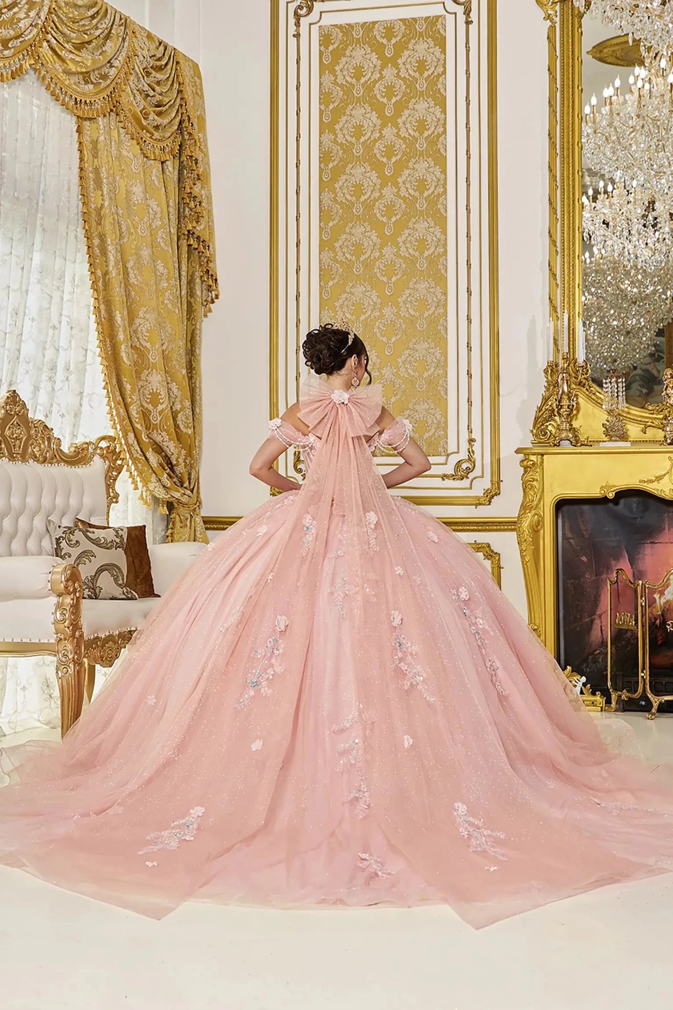 Pink ball gown with floral embroidery in a luxurious room with gold decor.