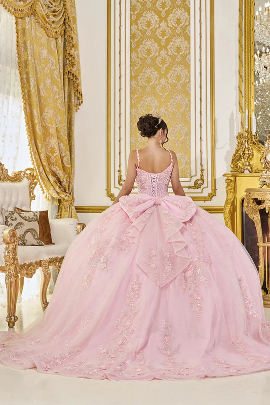 Woman in a pink gown standing in an opulent room with gold decor.