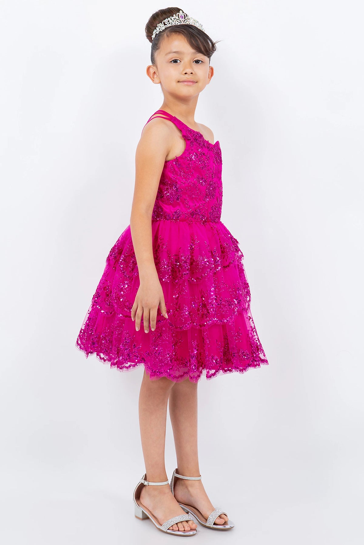 Trimmed by floral shimmer on the bodice, the Fuchsia kids party dress reveals its construction.