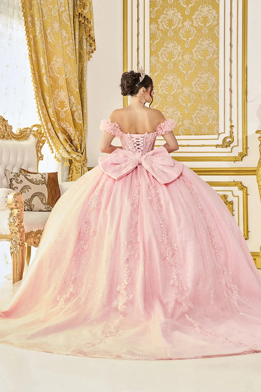 Woman standing back-facing in white ball gown with lace-up closure, off-shoulder bodice, glitter tulle layers, and cascading skirt