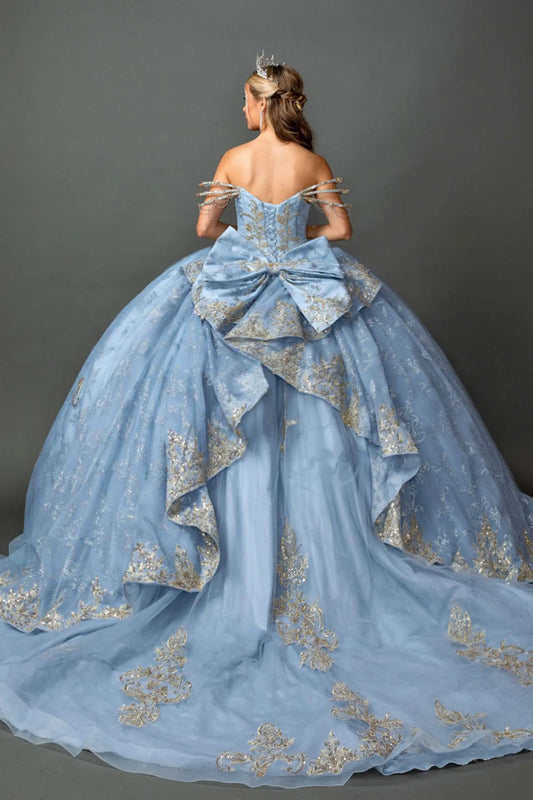 Full back view of a woman wearing a Dusty Blue quinceañera gown with corset lace-up back, glitter tulle layers, metallic embroidered accents, and off-shoulder sleeves