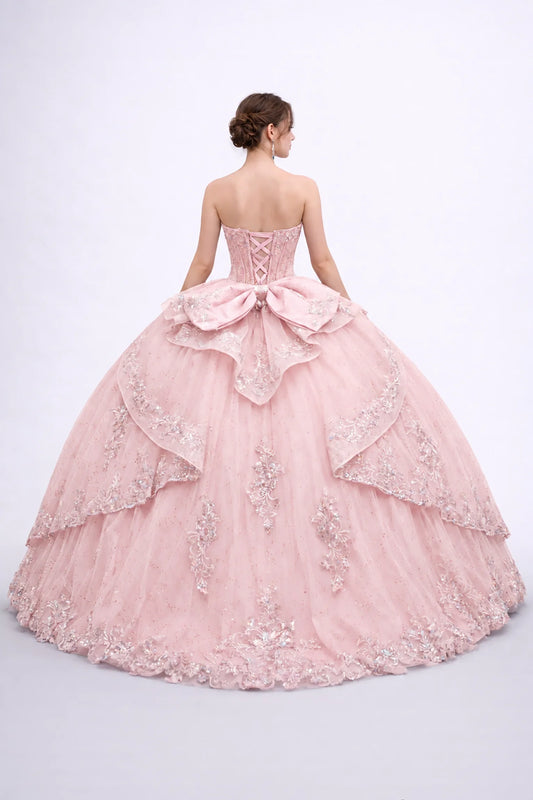 Back view of a Blush quinceañera dress showing a lace-up corset, oversized bow and embroidered layered tulle skirt