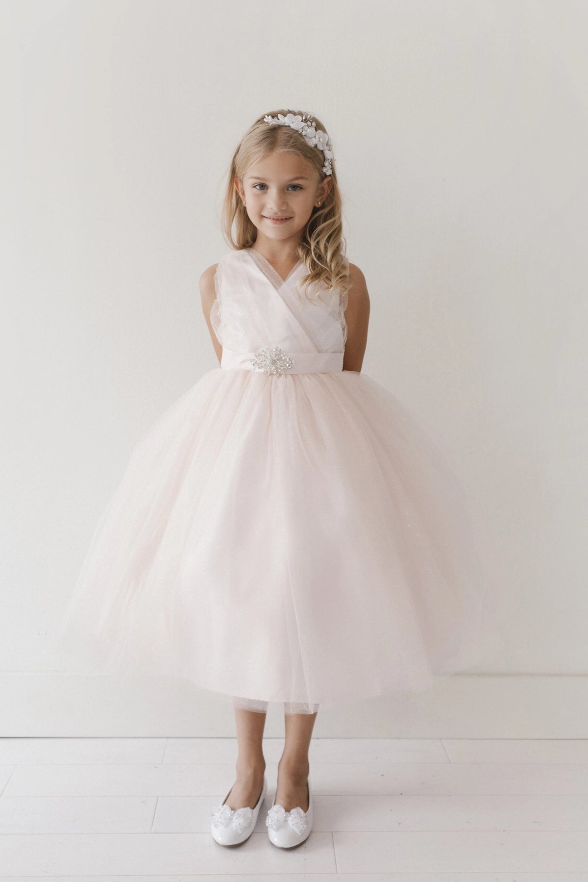 The Ivory kids pageant dress has a ruched V-neckline and rhinestone brooch.