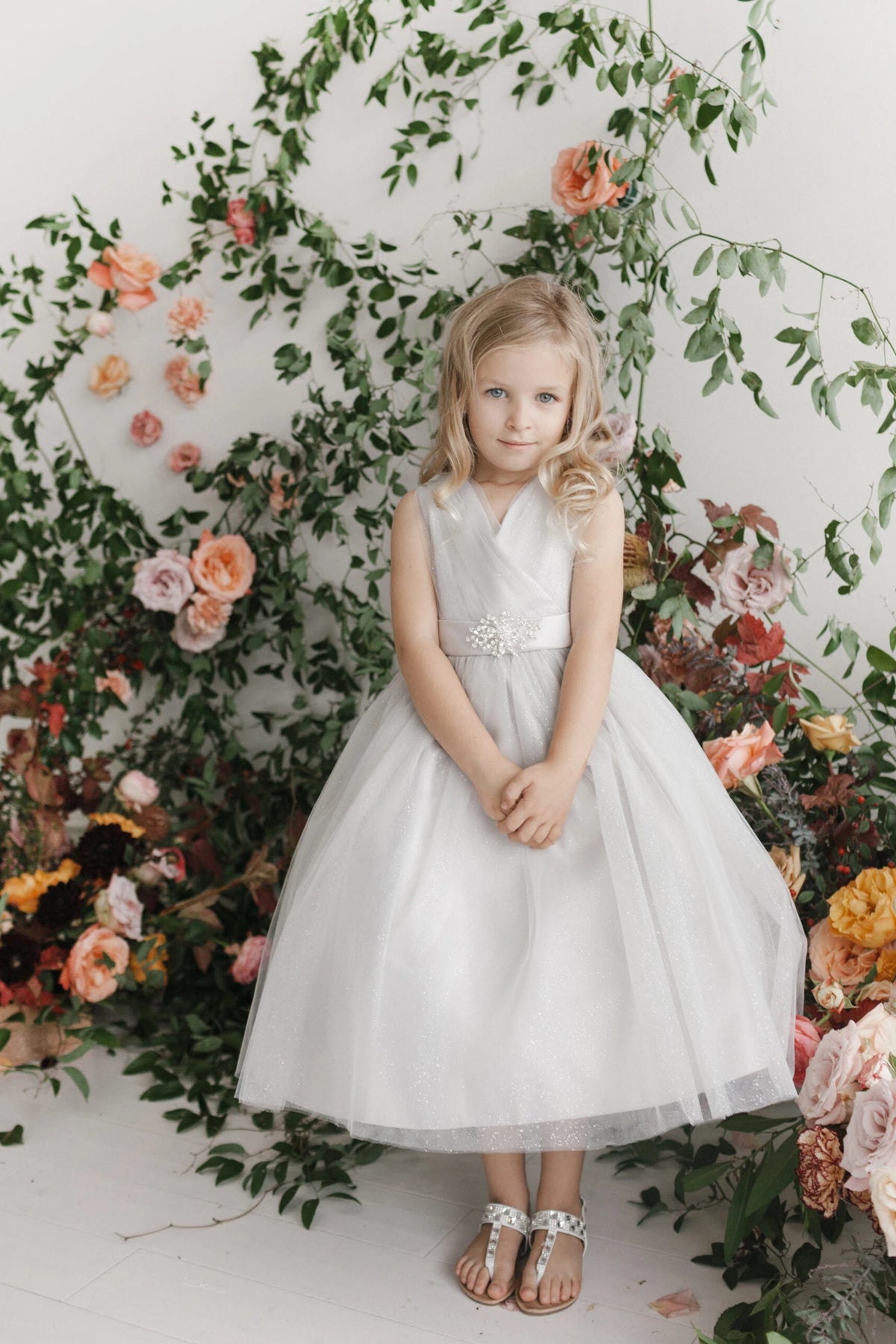 Visible details on the Ivory kids pageant dress include a ruched V-neckline and rhinestone brooch.