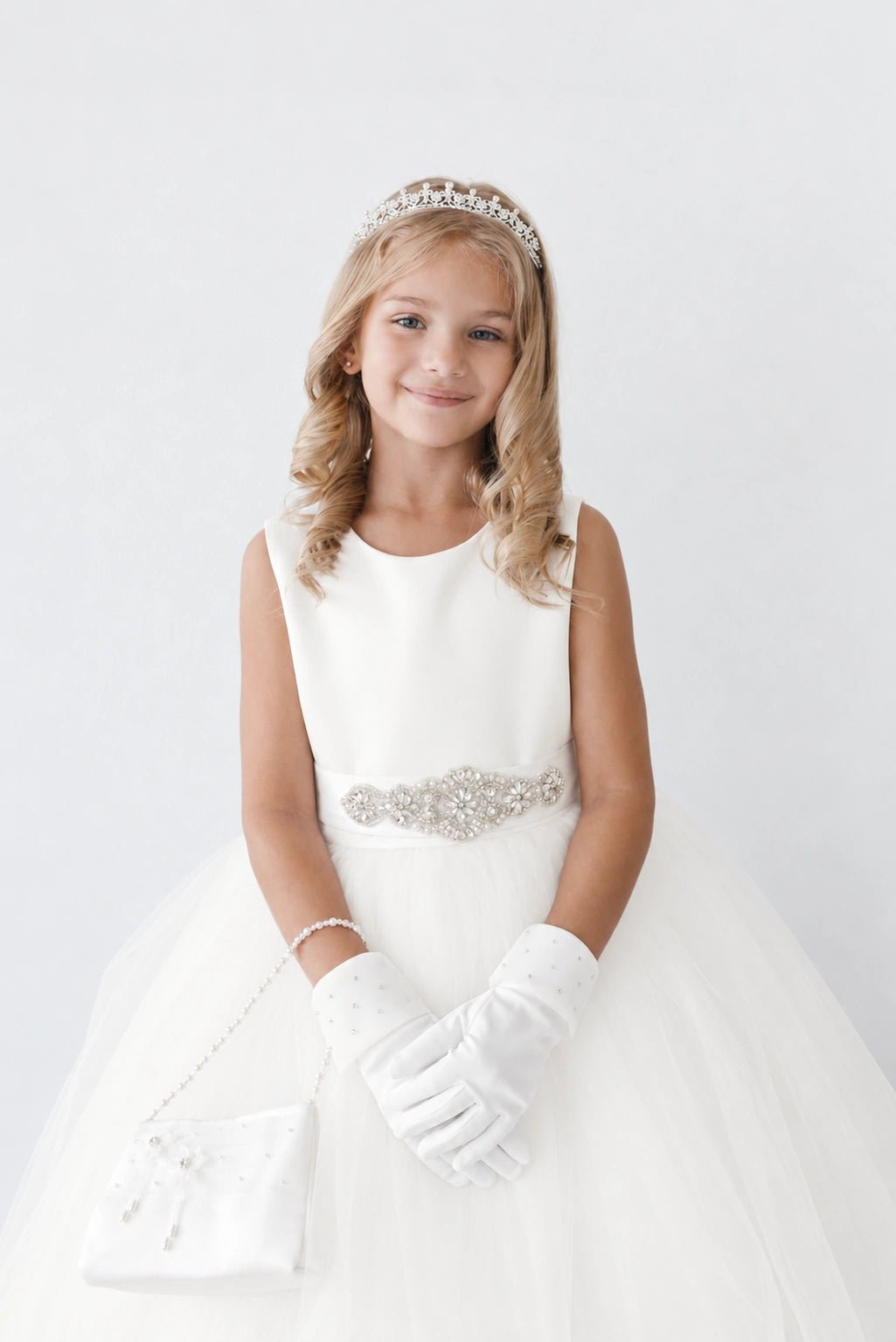 On this off-white flower girl dress, a beaded waist ornament is visible.