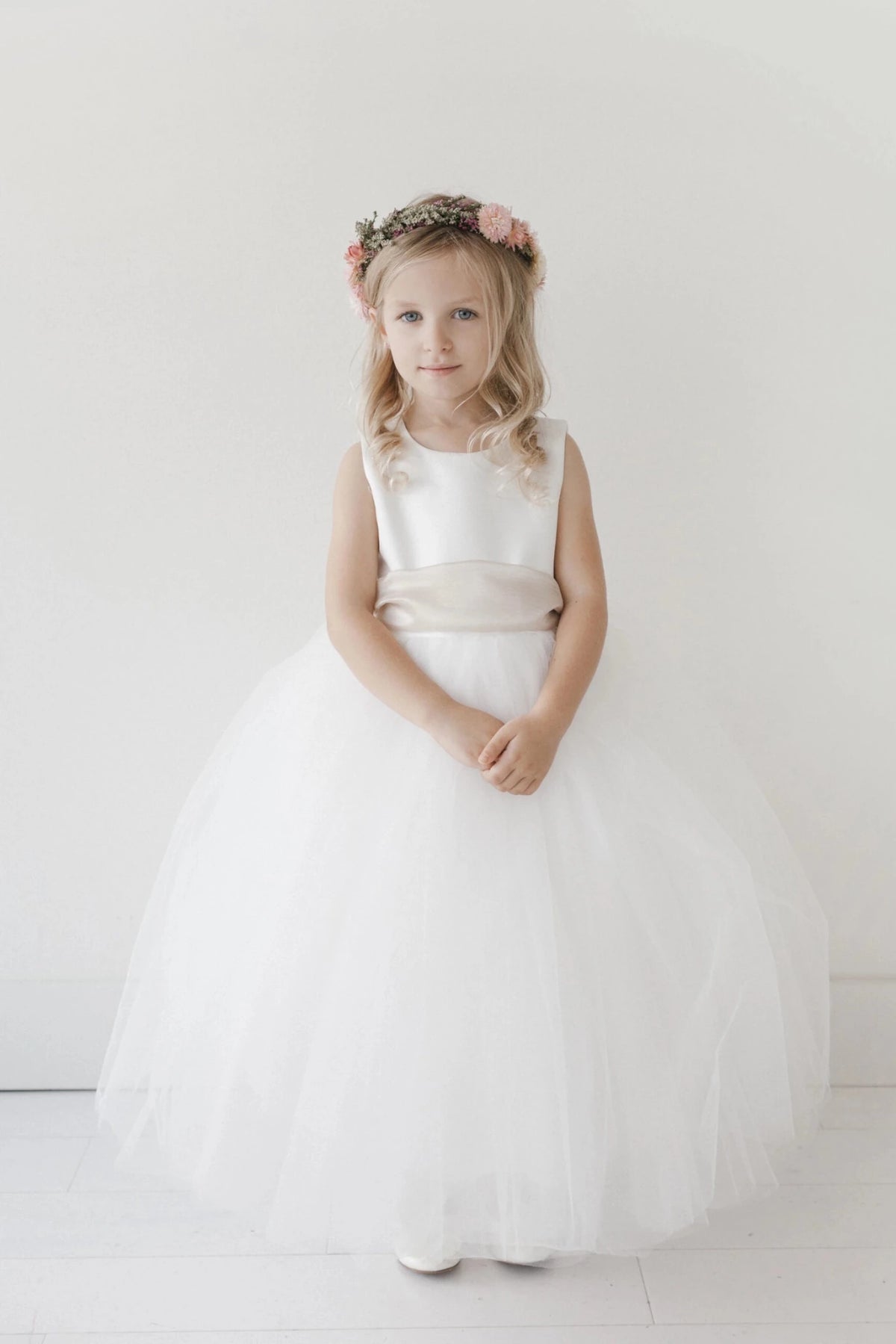 Full gathered tulle skirt accents this white flower girl dress.