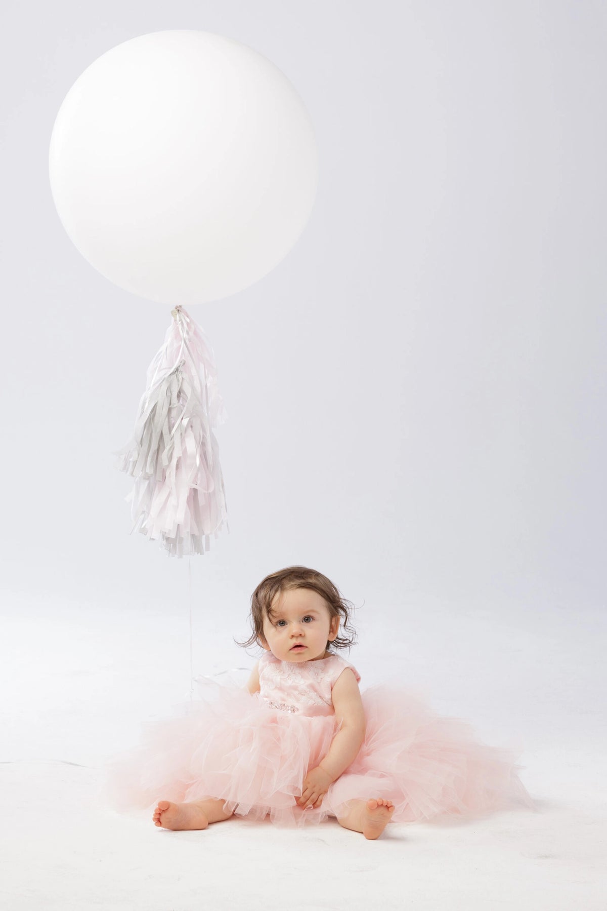 Soft tulle tiers are visible on the blush flower girl dress.