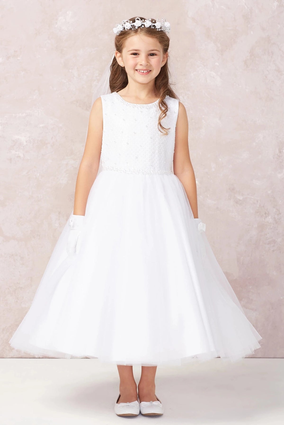In view: a smooth flared hem of a white flower girl dress.