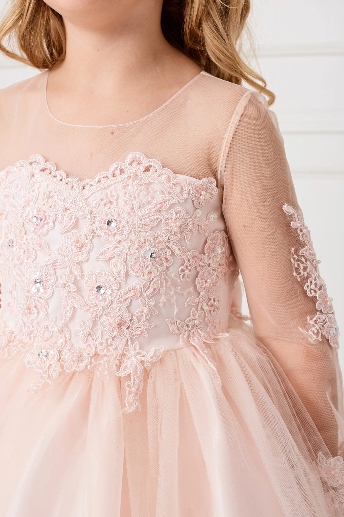 Seen from up close, this Blush kids pageant dress displays lace and sequins across the bodice.