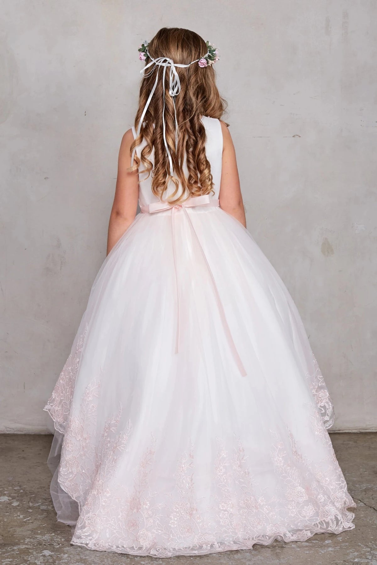Blush flower girl dress with a flowing lace train.