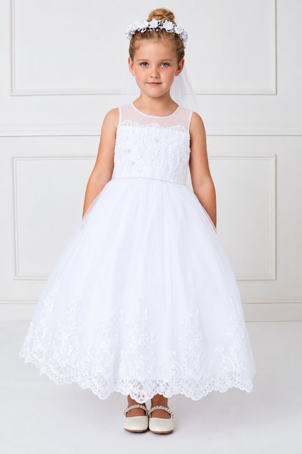 Branching lace rises up the white flower girl dress's skirt.