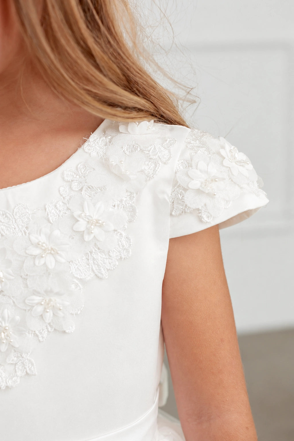 3D shoulder flowers on an off-white flower girl dress.