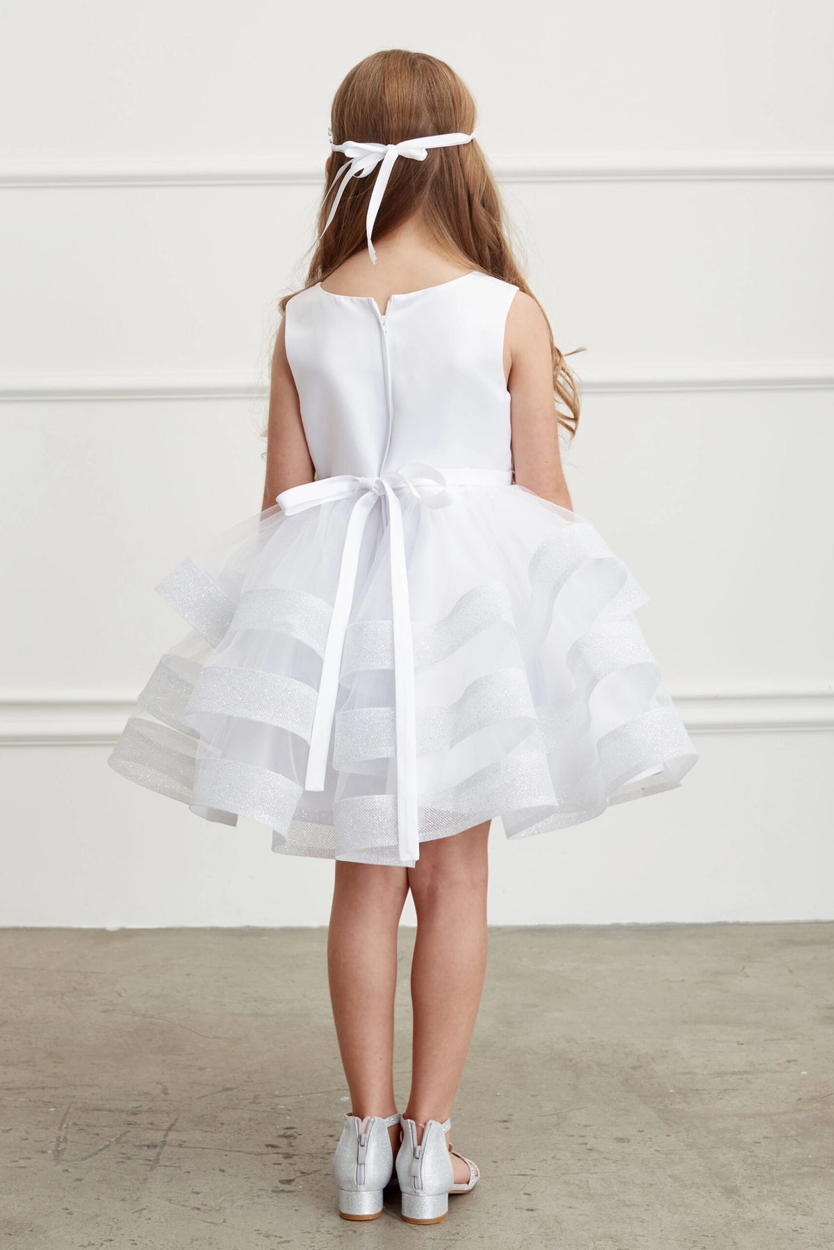 The White kids pageant dress has a tied sash across the back waist.