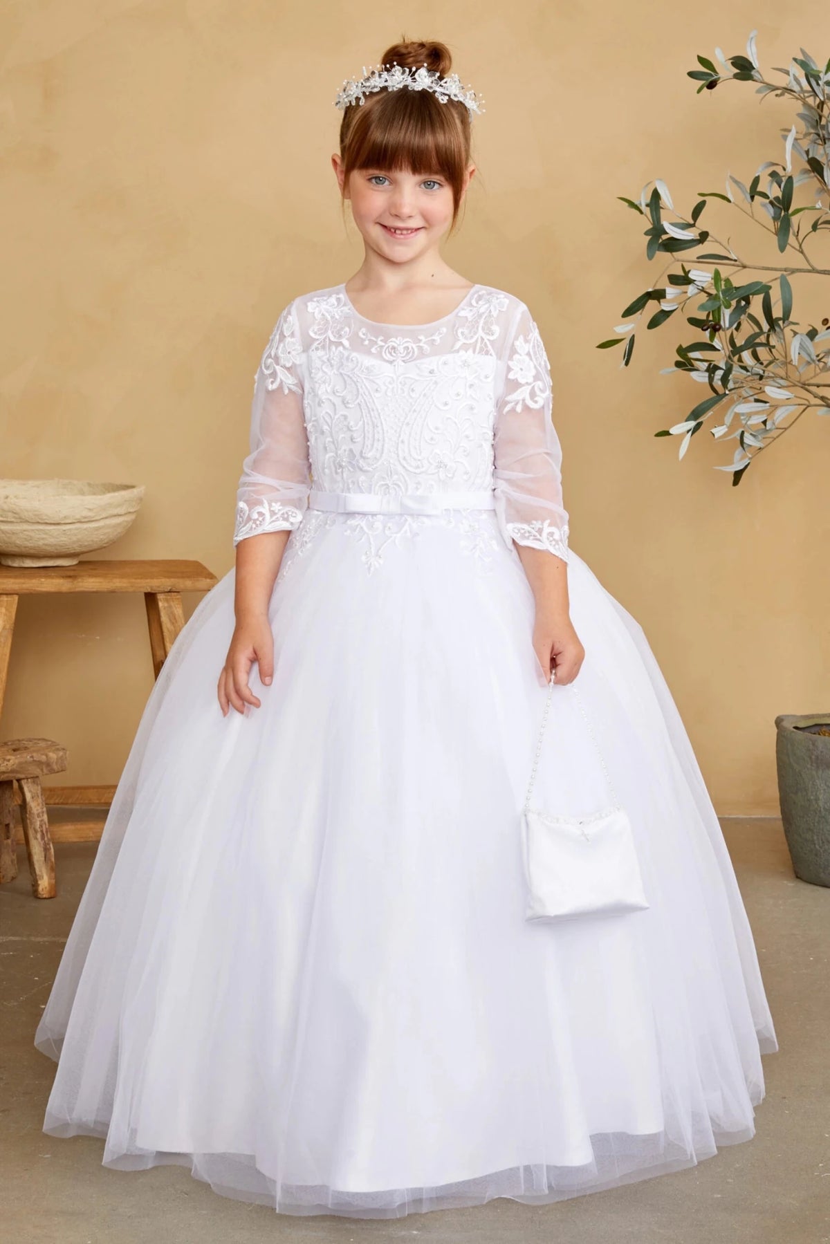 This white flower girl dress displays lace-trimmed sleeves.