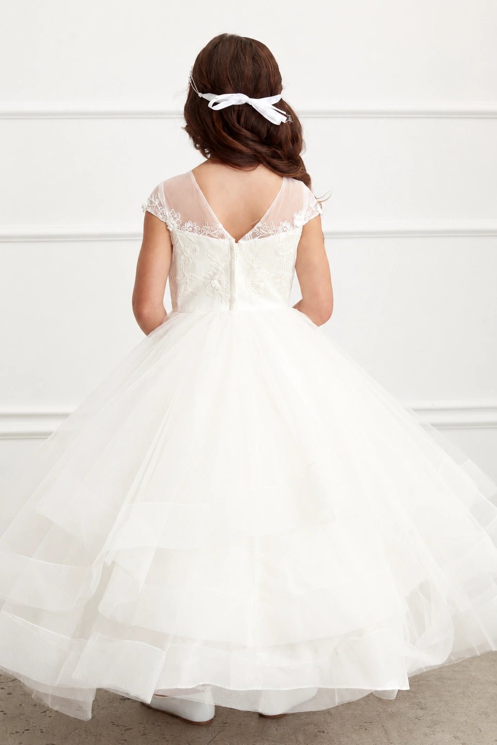 Wide bands edge each skirt layer of this off-white flower girl dress.