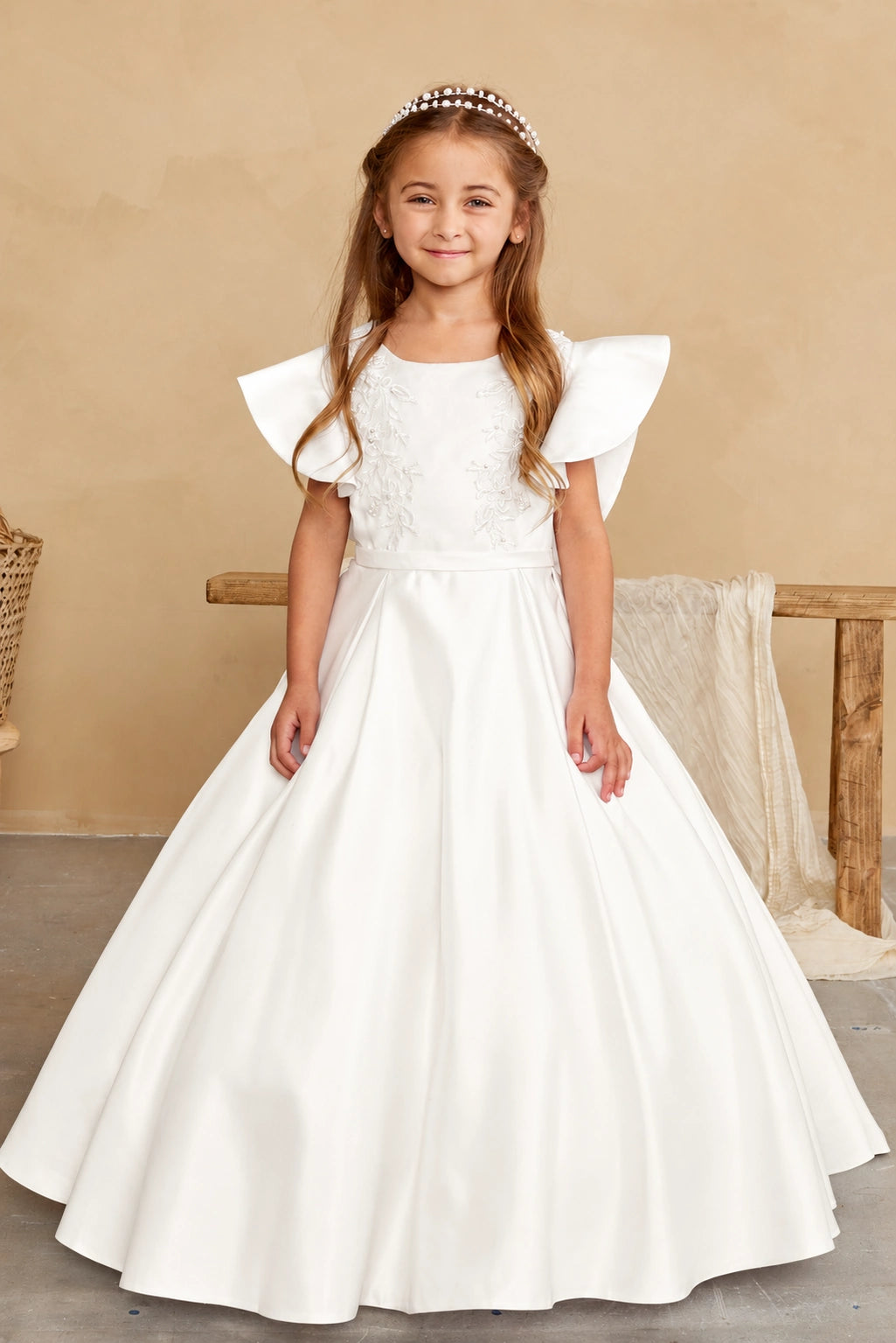 Wide folds give the off-white flower girl dress's satin skirt volume.