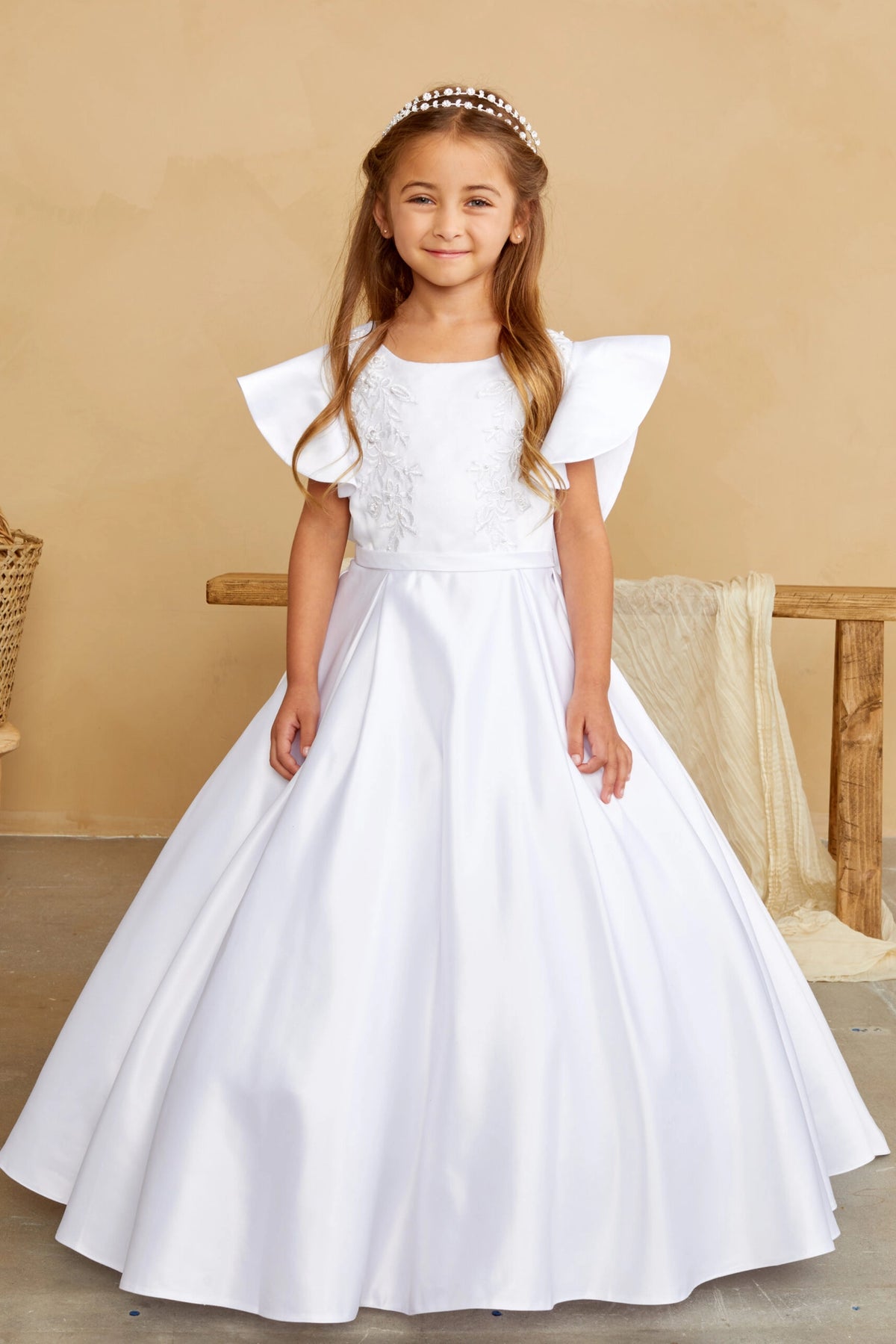Smooth flared skirt accents this white flower girl dress.