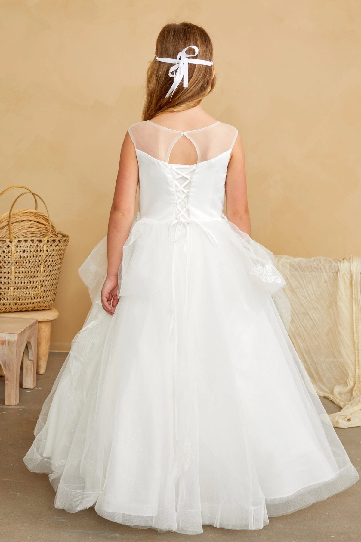 Crisscross ribbons lace the back of this off-white flower girl dress.