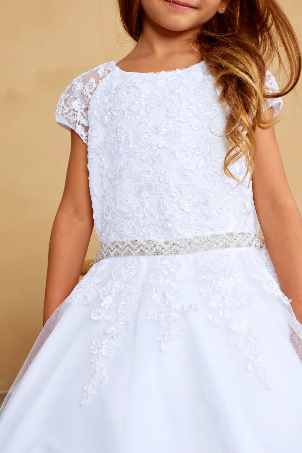 Lattice-like beadwork defines the white flower girl dress's slim belt.