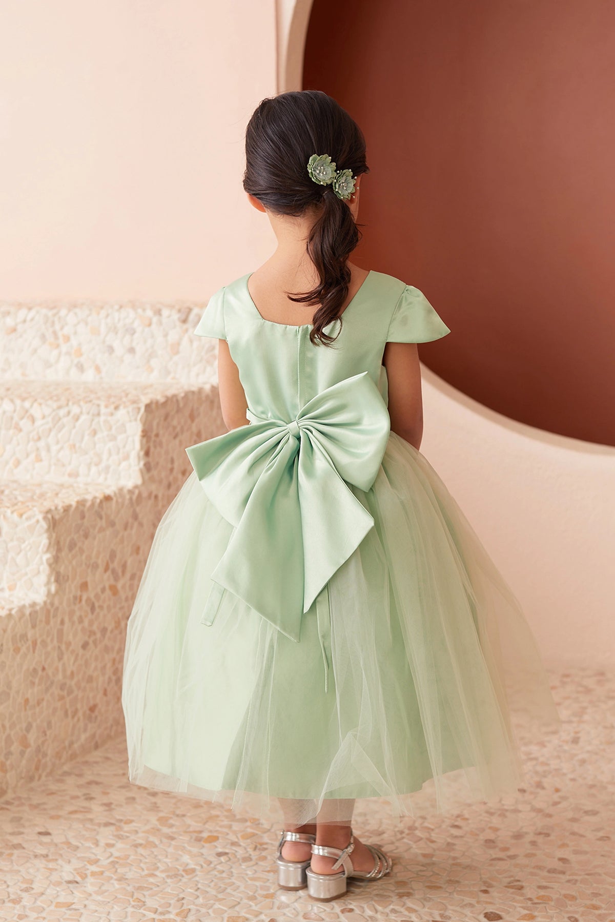 The Sage kids pageant dress has a large satin bow and square back neckline.