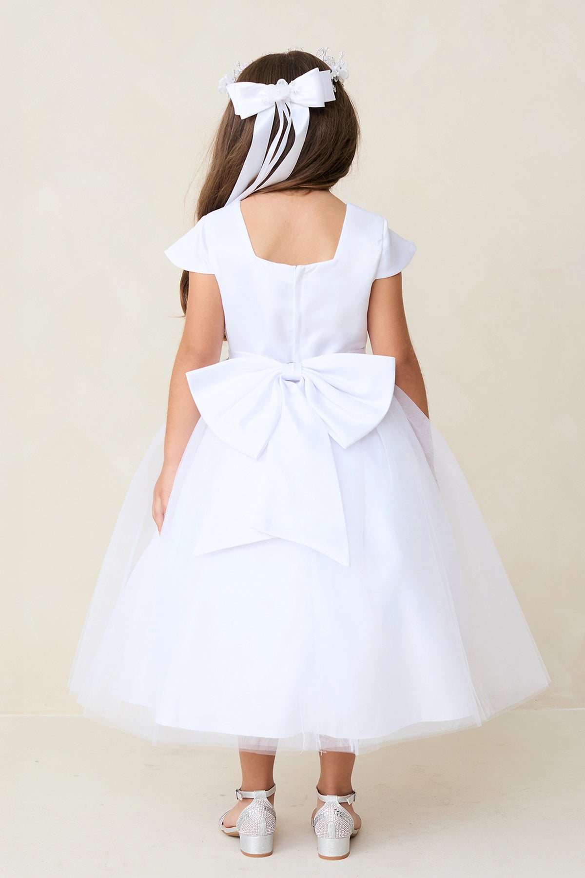 The White kids pageant dress has a large satin bow and square back neckline.