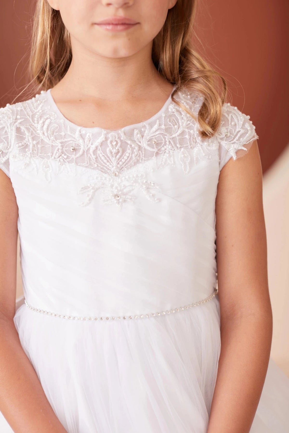 Diagonal pleated bodice on a white flower girl dress.