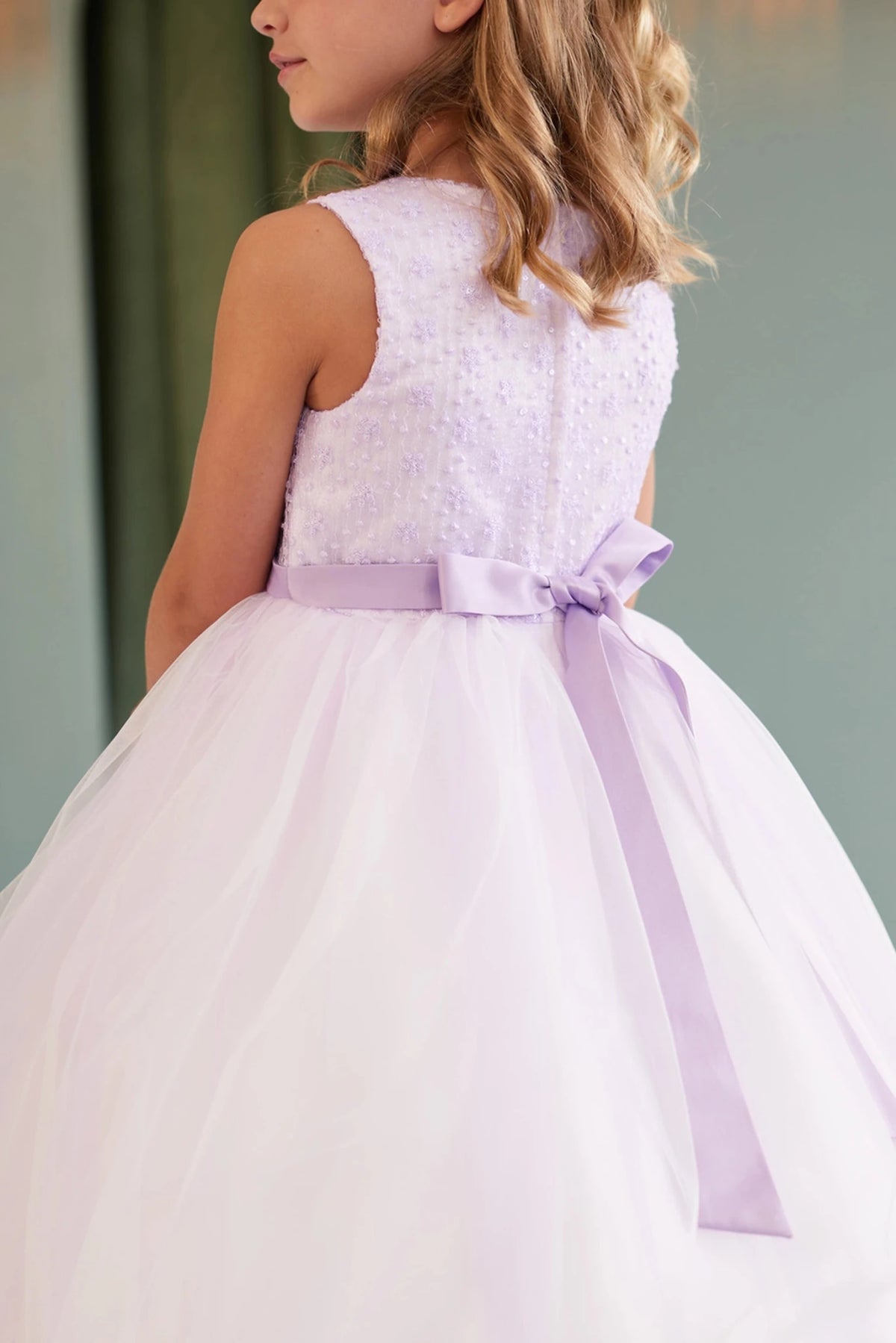 With a small satin back bow, a lilac flower girl dress.