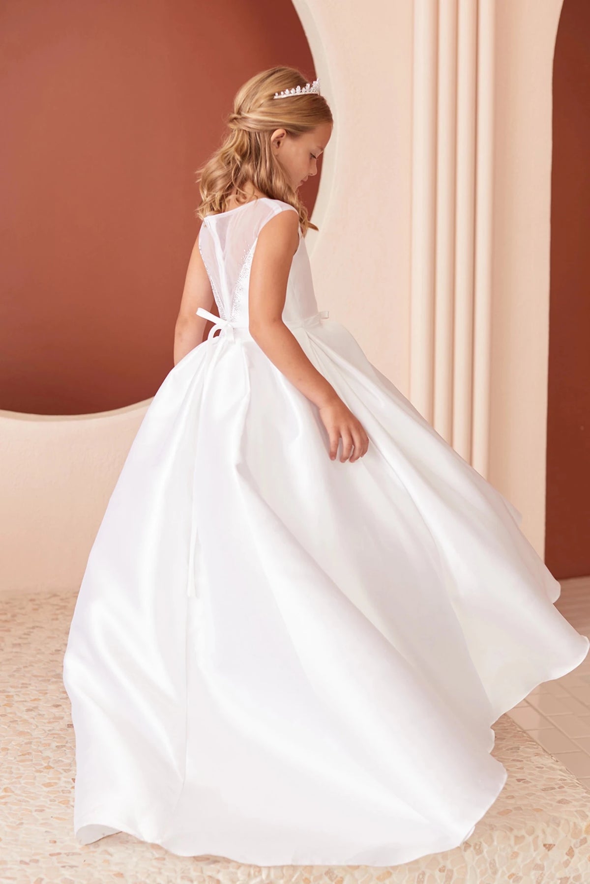 With a wide pleated skirt, a white flower girl dress.