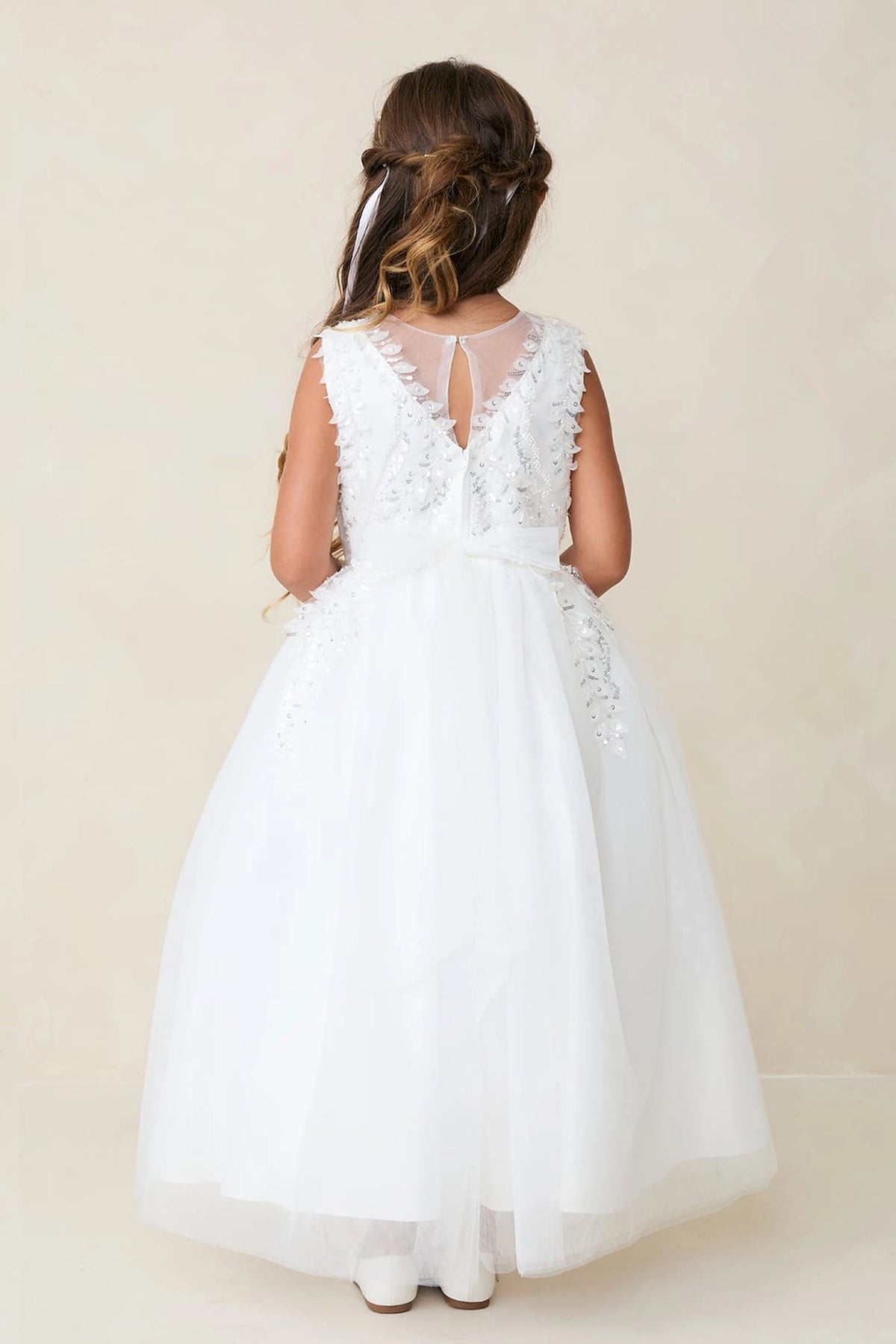 Floral lace borders the sheer back V of an off-white flower girl dress.