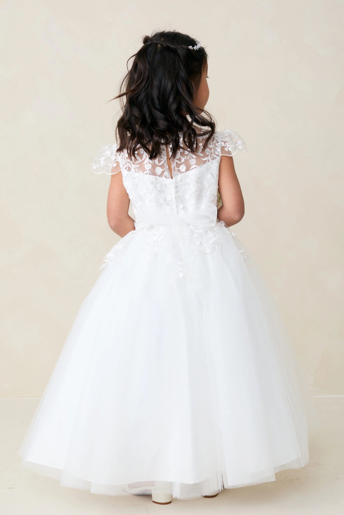 Sheer lace back is visible on the off-white flower girl dress.